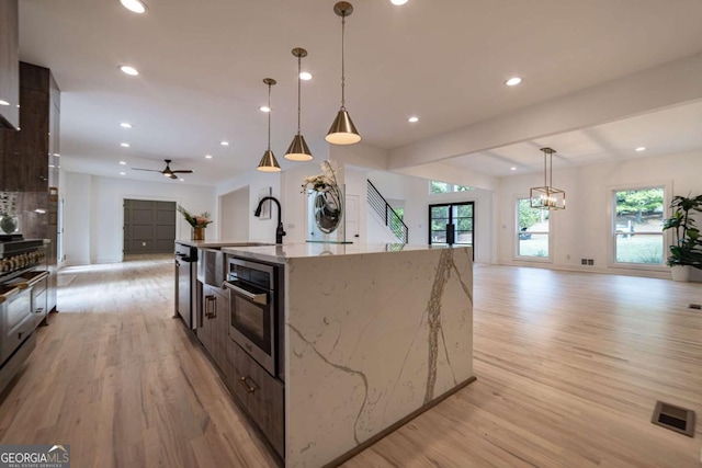 4 Bentley Trace Mnr, Atlanta, GA 30327 - kitchen with open floor plan, light wood-style floors, oven, an island with sink, and recessed lighting