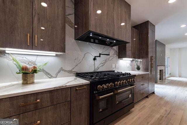 4 Bentley Trace Mnr, Atlanta, GA 30327 - kitchen featuring double oven range, modern cabinets, decorative backsplash, light wood-style flooring, and range hood