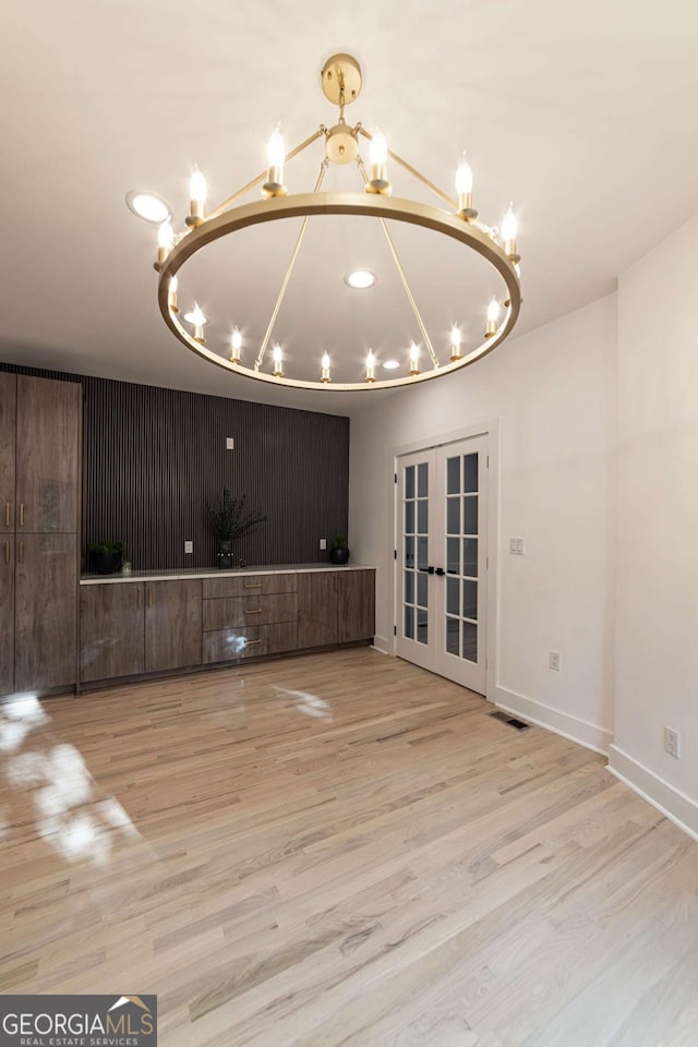 4 Bentley Trace Mnr, Atlanta, GA 30327 - unfurnished living room featuring a chandelier, french doors, and wood finished floors