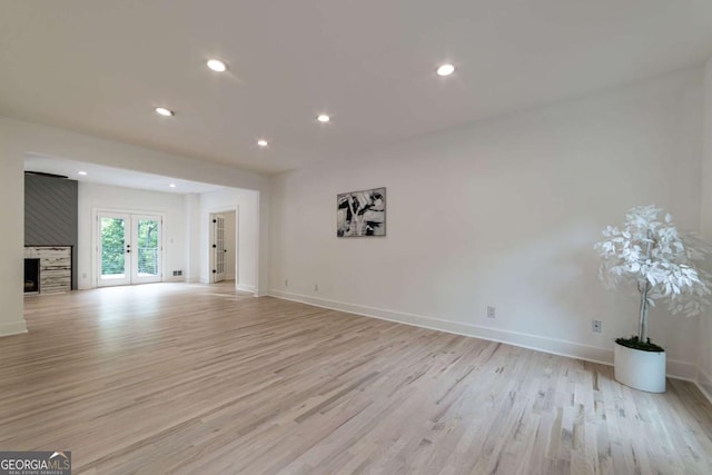 4 Bentley Trace Mnr, Atlanta, GA 30327 - unfurnished living room featuring light wood-type flooring, recessed lighting, a fireplace, and french doors