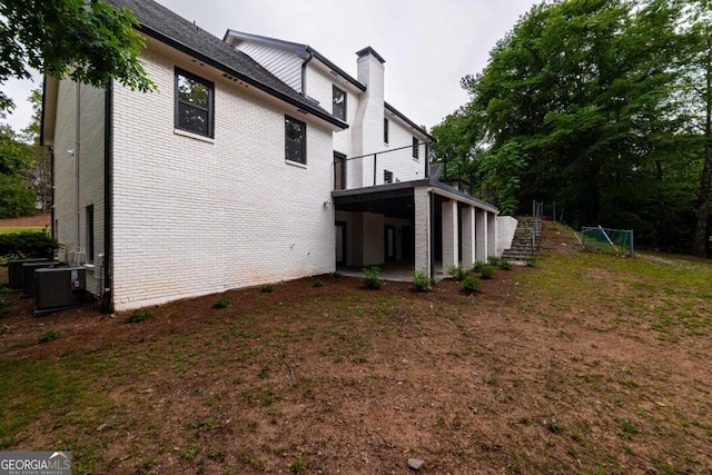 4 Bentley Trace Mnr, Atlanta, GA 30327 - view of side of home with brick siding, a chimney, stairway, and a balcony