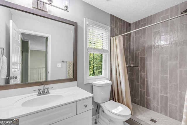 4027 Mount Vernon Dr, Woodstock, GA 30189 - full bathroom with plenty of natural light, a tile shower, a textured ceiling, vanity, and toilet