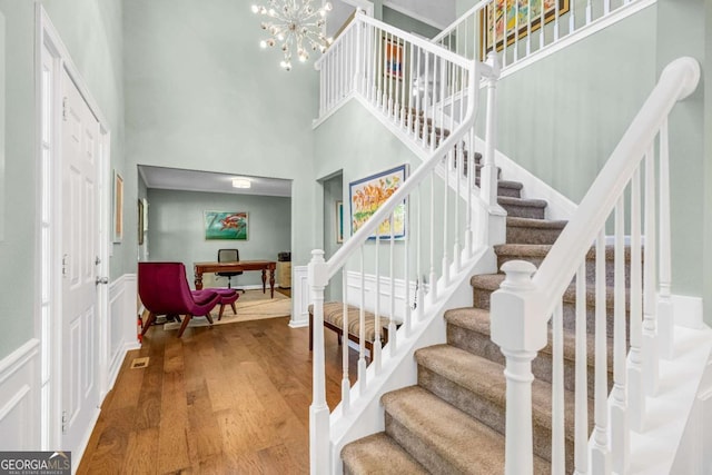 4027 Mount Vernon Dr, Woodstock, GA 30189 - stairway featuring a high ceiling, wood finished floors, and a chandelier