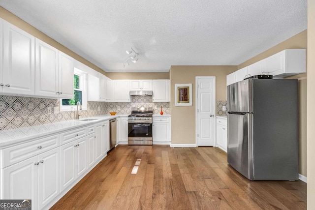 4027 Mount Vernon Dr, Woodstock, GA 30189 - kitchen with appliances with stainless steel finishes, a sink, a textured ceiling, wood finished floors, and light countertops