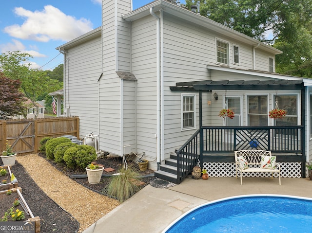 1482 Pinebark Ct, Grayson, GA 30017 - back of house with fence, an outdoor pool, a chimney, and a patio