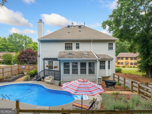 1482 Pinebark Ct, Grayson, GA 30017 - back of property featuring a patio area, a chimney, a fenced backyard, roof with shingles, and a garden