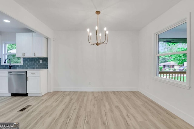 644 Church St NW, Atlanta, GA 30318 - kitchen featuring stainless steel dishwasher, light wood-style floors, light countertops, a chandelier, and backsplash
