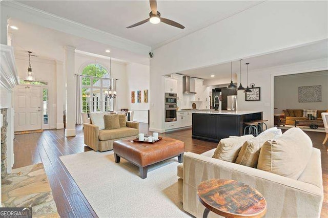 living area with ornamental molding, hardwood / wood-style floors, ceiling fan, recessed lighting, and a chandelier
