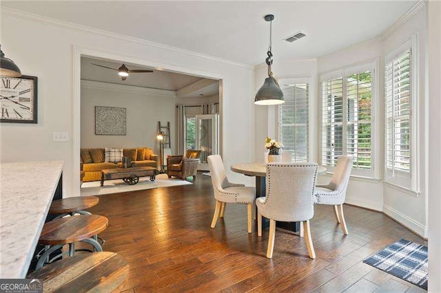 dining room featuring ornamental molding, dark wood-style flooring, and baseboards