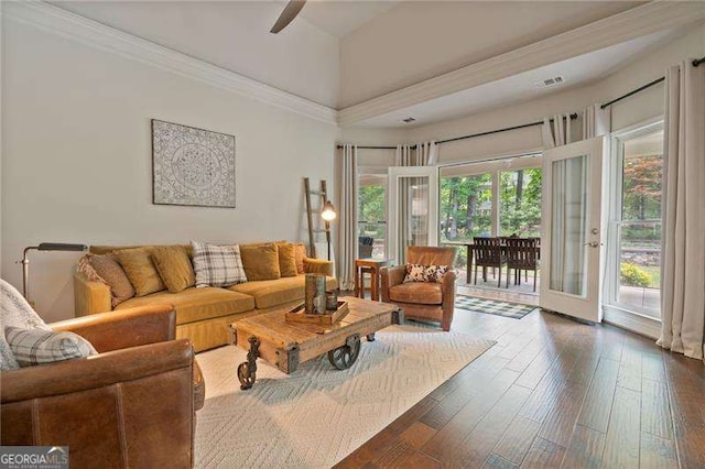 living area featuring dark wood-type flooring, a ceiling fan, and crown molding