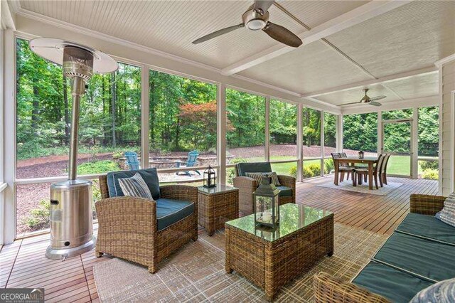 sunroom with a ceiling fan, outdoor dining space, and plenty of natural light