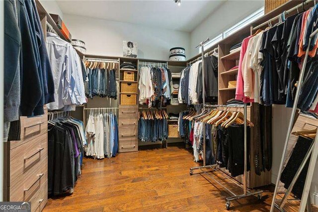 walk in closet with wood finished floors