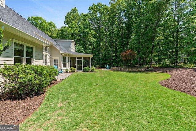 view of green lawn featuring a sunroom