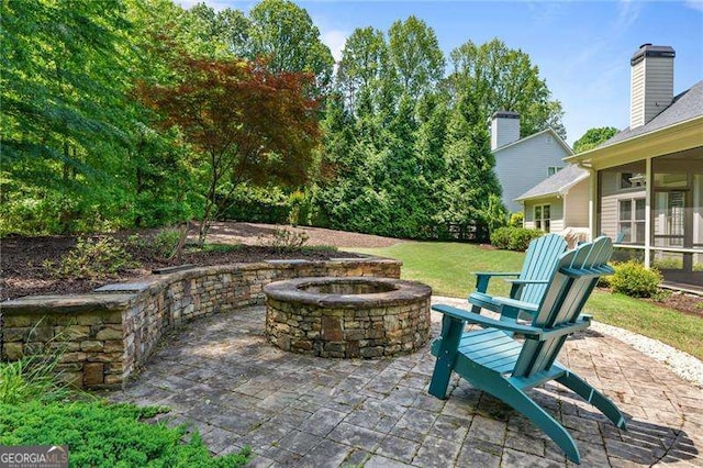 view of patio / terrace with a fire pit and a sunroom