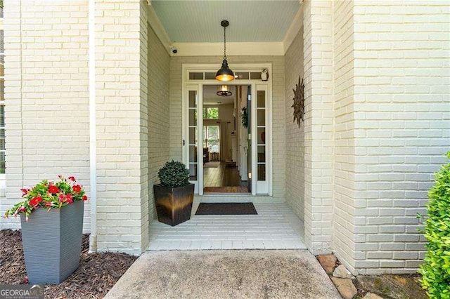doorway to property featuring brick siding