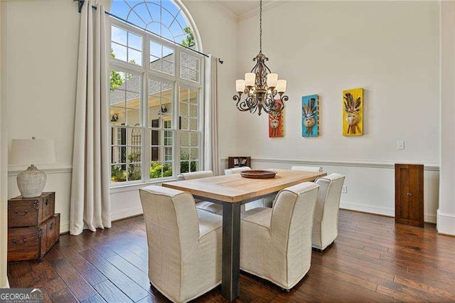 dining room featuring a chandelier, ornamental molding, dark wood-type flooring, and baseboards