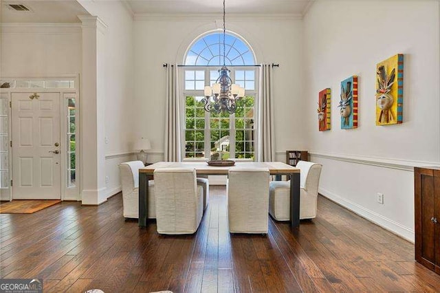 dining area featuring a chandelier, dark wood-style floors, ornamental molding, and baseboards