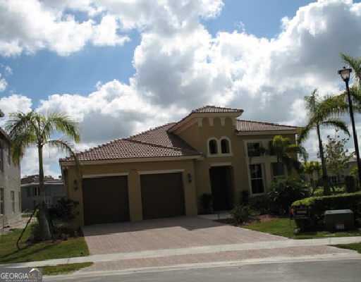 mediterranean / spanish-style home featuring a garage, driveway, a tile roof, and stucco siding