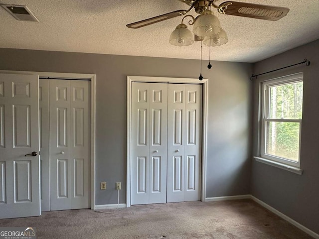 304 Joshua Tree Dr Unit 304, Augusta, GA 30907 - unfurnished bedroom with multiple closets, carpet, a textured ceiling, baseboards, and a ceiling fan
