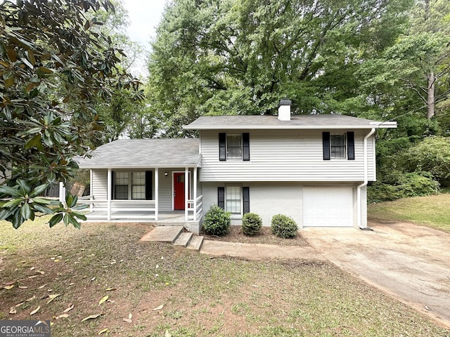3879 Mcgill Ln, Decatur, GA 30034 - split level home featuring covered porch, concrete driveway, an attached garage, a chimney, and brick siding