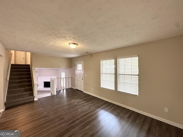 3879 Mcgill Ln, Decatur, GA 30034 - unfurnished living room featuring dark wood-style floors, baseboards, a textured ceiling, and stairway