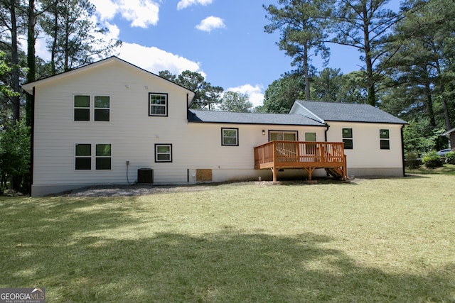 back of house with a deck, a lawn, and roof with shingles