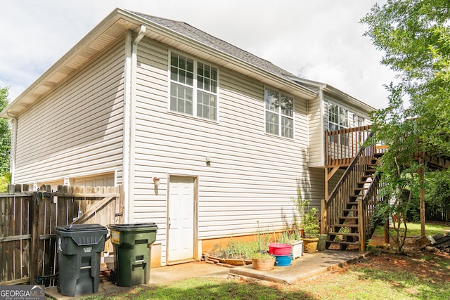 back of house with fence, a wooden deck, and stairs