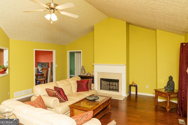living area featuring a textured ceiling, lofted ceiling, dark wood-style flooring, ceiling fan, and baseboards