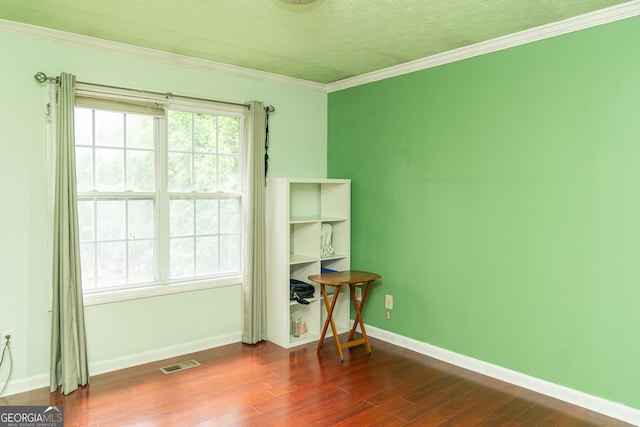 spare room with dark wood finished floors, baseboards, crown molding, and a textured ceiling