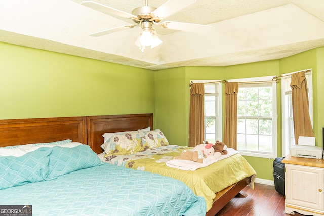 bedroom with dark wood-style floors, baseboards, and a ceiling fan