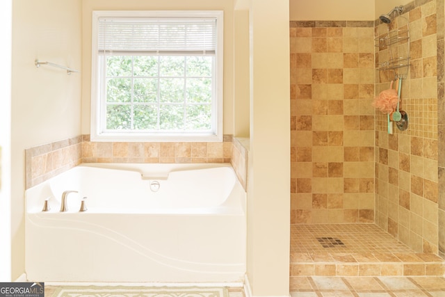full bathroom with a bath and a tile shower