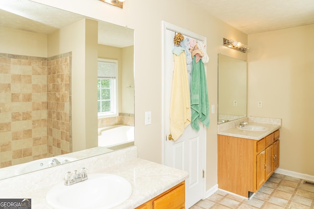 full bath with a textured ceiling, vanity, a tub, and baseboards