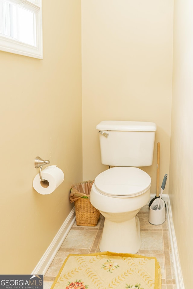 bathroom featuring toilet, tile patterned floors, and baseboards