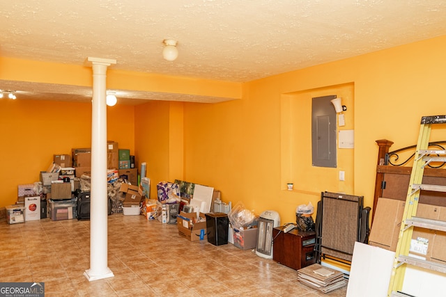 finished below grade area featuring electric panel and a textured ceiling