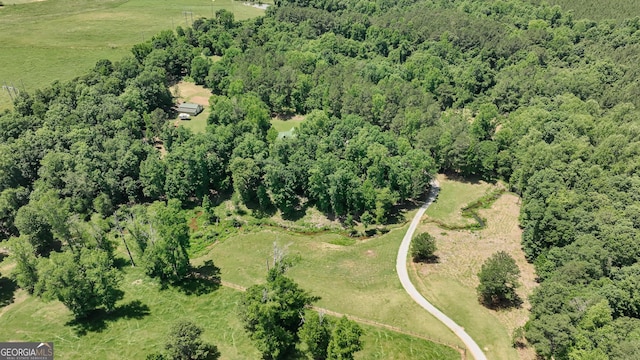 view of property location featuring a heavily wooded area and rural landscape
