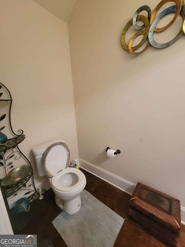 bathroom featuring baseboards, toilet, and wood finished floors