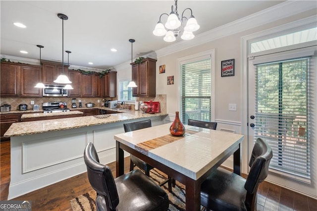 kitchen featuring stainless steel appliances, ornamental molding, backsplash, dark wood-style flooring, and dark brown cabinetry