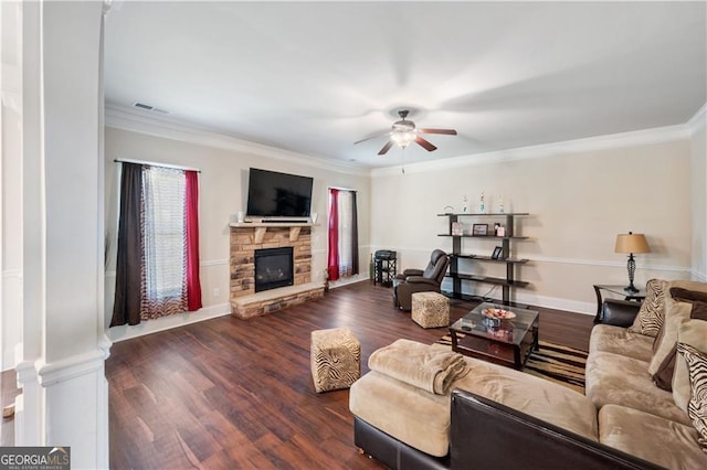 living area featuring a ceiling fan, a fireplace, dark wood finished floors, ornamental molding, and baseboards
