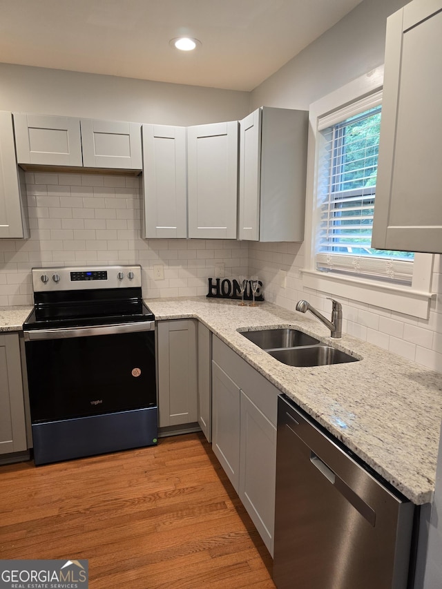 4075 SW Fairburn Ave SW, Atlanta, GA 30331 - kitchen featuring stainless steel appliances, gray cabinets, backsplash, light stone counters, and recessed lighting