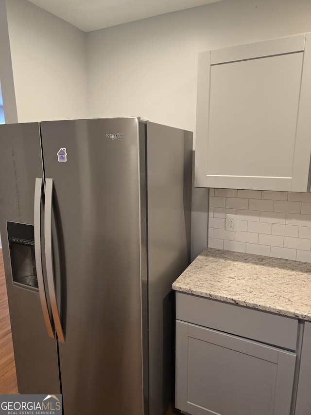 4075 SW Fairburn Ave SW, Atlanta, GA 30331 - kitchen with stainless steel refrigerator with ice dispenser, gray cabinets, decorative backsplash, and light stone counters