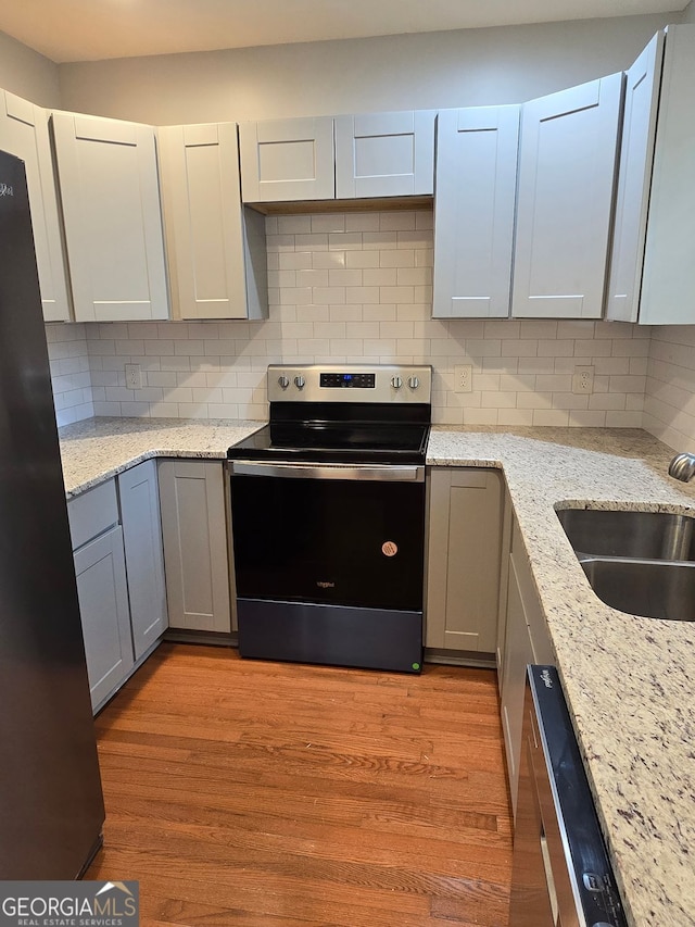 4075 SW Fairburn Ave SW, Atlanta, GA 30331 - kitchen with stainless steel appliances, tasteful backsplash, light wood-type flooring, and gray cabinetry