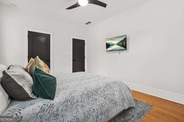 bedroom with baseboards, wood finished floors, and a ceiling fan