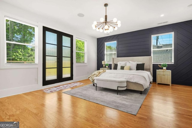 bedroom featuring a chandelier, wood finished floors, and baseboards