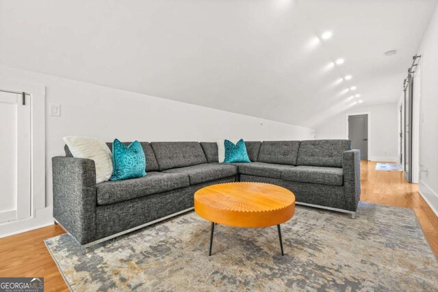 living room with wood finished floors, lofted ceiling, and baseboards