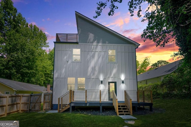 rear view of house featuring board and batten siding, a wooden deck, and stairway