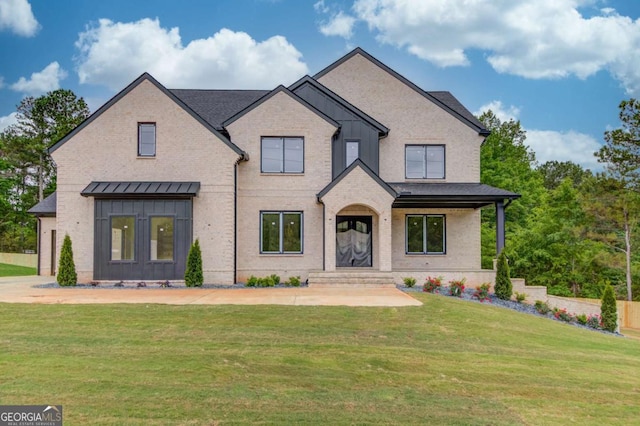 view of front of property with board and batten siding, a front yard, and brick siding