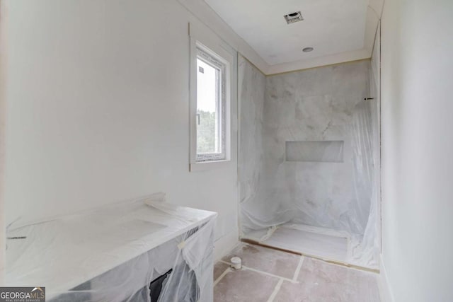 full bathroom with a marble finish shower