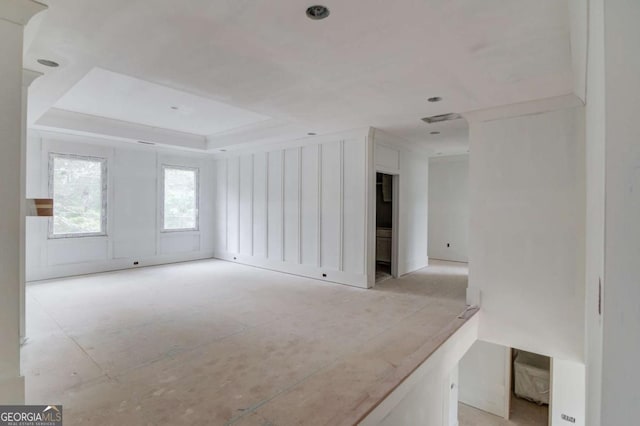 unfurnished living room with a tray ceiling