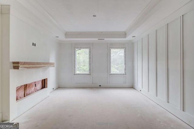 unfurnished living room with a fireplace and a tray ceiling