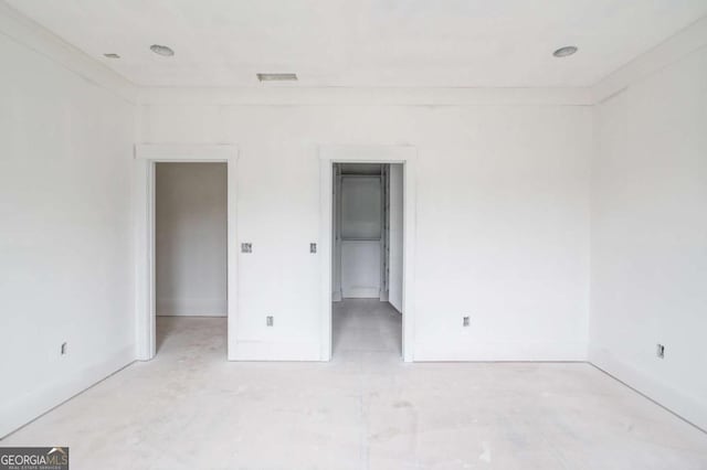 unfurnished bedroom with baseboards and a spacious closet